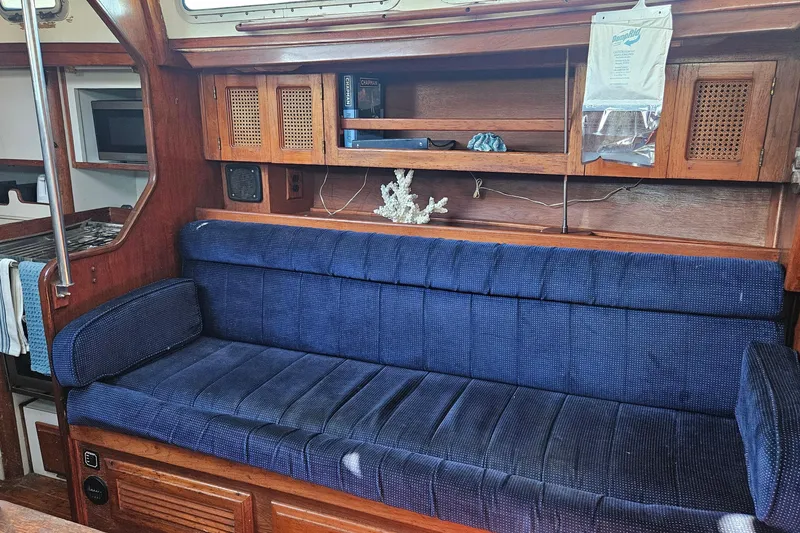 Slide: The Image of Interior of 1989 ENDEAVOR 42 yacht with blue cushioned seating and wooden cabinetry. - 32