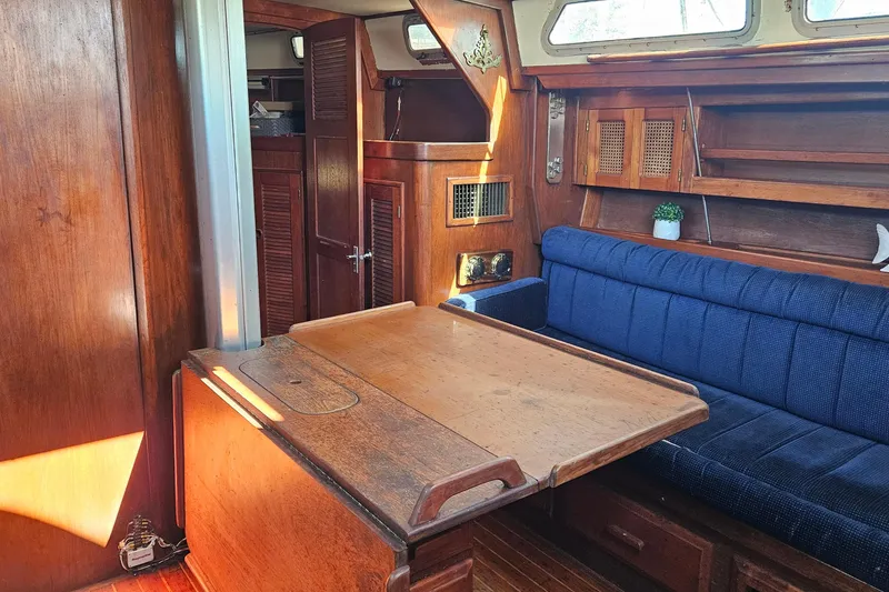 Slide: The Image of Interior of 1989 ENDEAVOR 42 sailboat with wooden table and blue cushioned seating. - 33