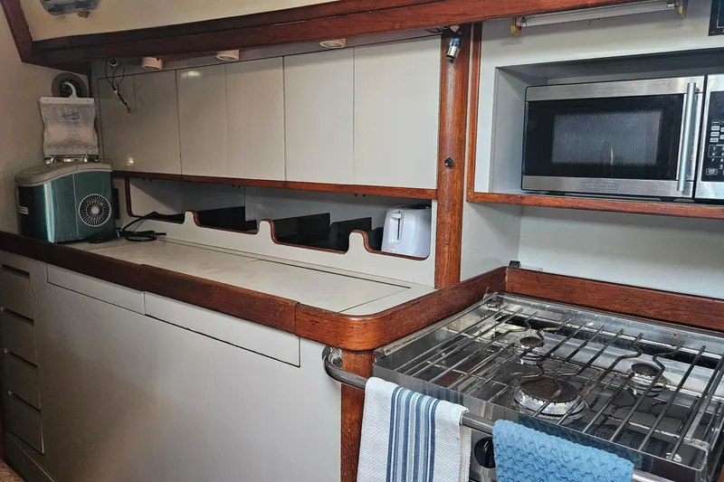 Slide: The Image of Galley kitchen in 1989 ENDEAVOR 42 yacht with stove, microwave, and wooden accents. - 38