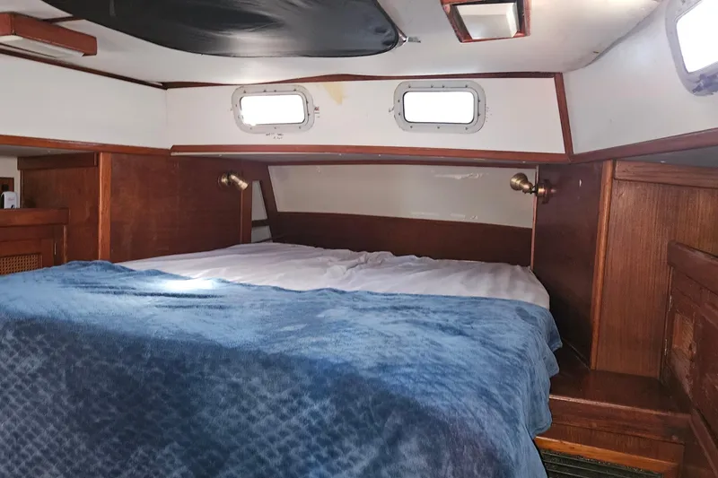 Slide: The Image of Cozy cabin interior of 1989 ENDEAVOR 42 sailboat with wooden accents and blue bedding. - 40