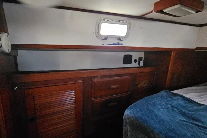 Slide: The Image of Interior of 1989 ENDEAVOR 42 sailboat with wooden cabinetry and small window. - 42