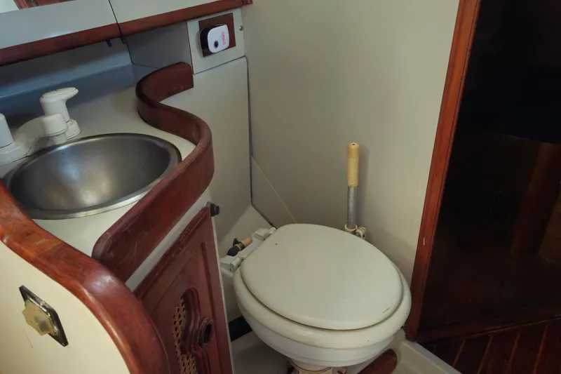 Slide: The Image of 1989 ENDEAVOR 42 yacht bathroom with sink and toilet, featuring wooden accents. - 46