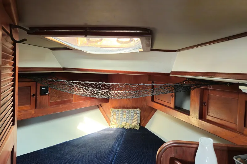 Slide: The Image of Cozy cabin interior of 1989 ENDEAVOR 42 sailboat with wooden accents and netting. - 60