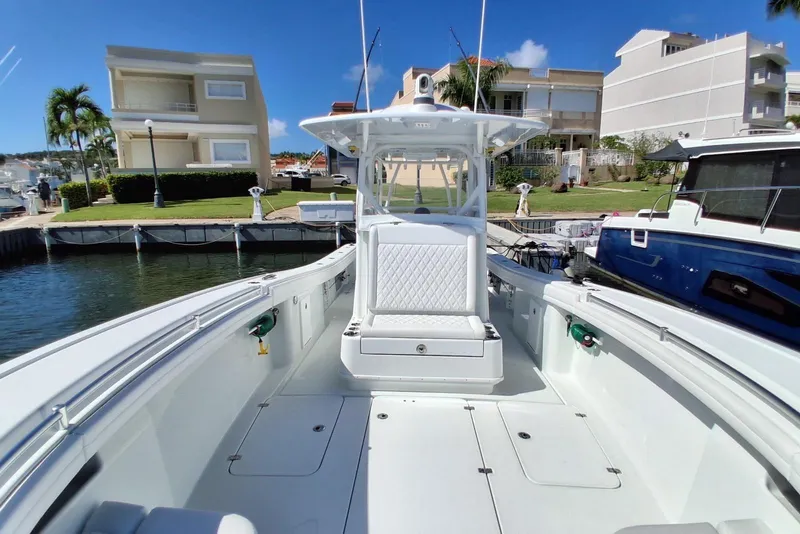 Slide: The Image of 2023 Yellowfin 36 Offshore boat docked in a marina, showcasing spacious deck and seating. - 10