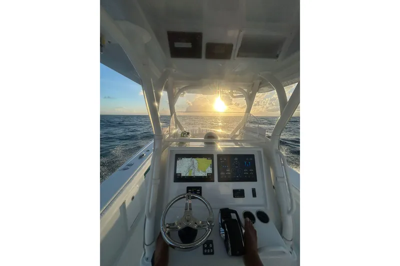 Slide: The Image of 2023 Yellowfin 36 Offshore boat dashboard with ocean sunset view. - 17
