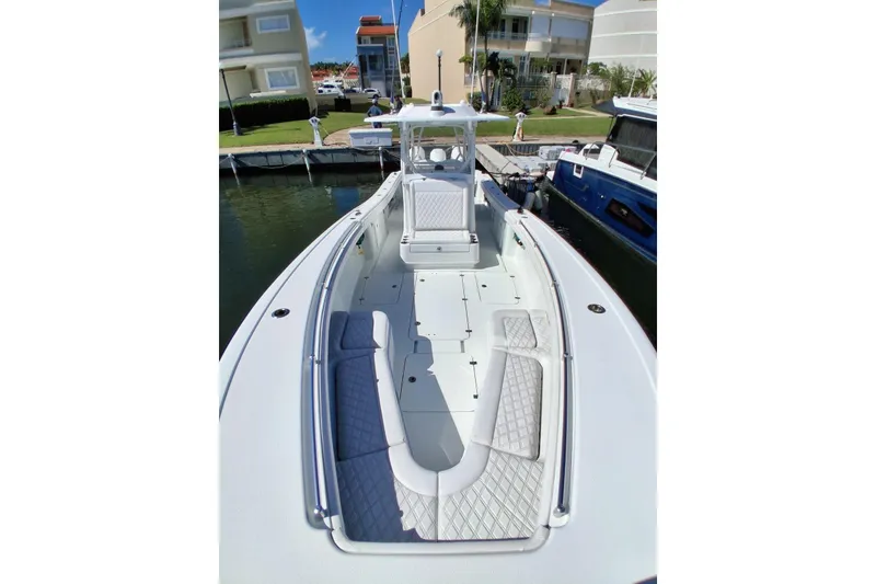 Slide: The Image of 2023 Yellowfin 36 Offshore boat docked, showcasing spacious deck and seating. - 5