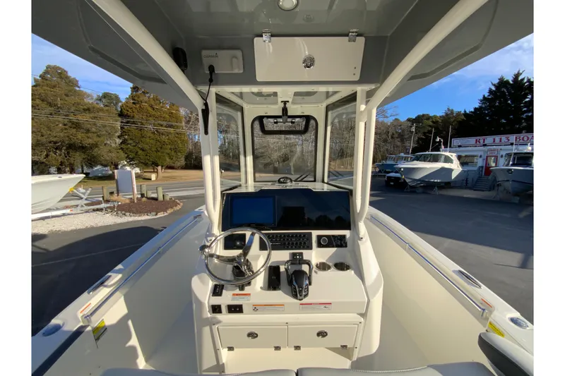 Slide: The Image of 2026 Cobia 245 Center Console boat interior with steering wheel and control panel. - 11