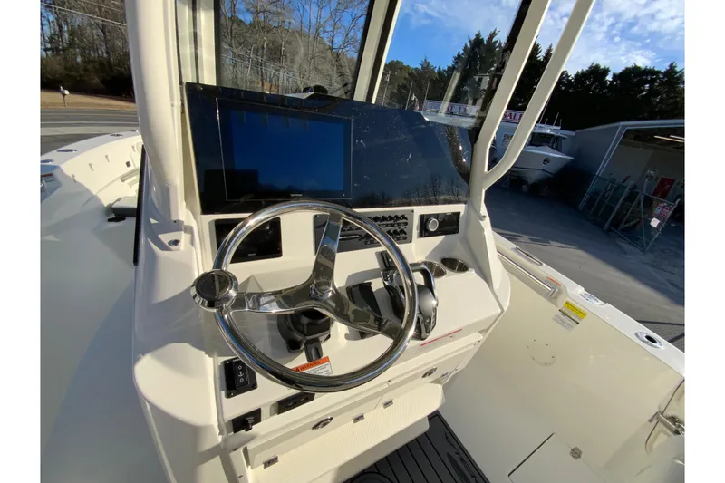 Slide: The Image of 2026 Cobia 245 Center Console boat dashboard with steering wheel and navigation display. - 12
