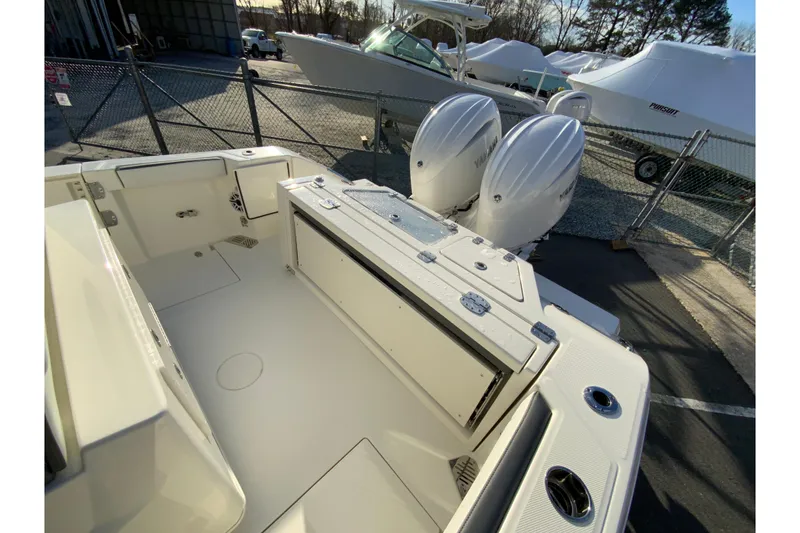 Slide: The Image of 2026 Cobia 245 Center Console boat with dual outboard engines in a marina setting. - 13