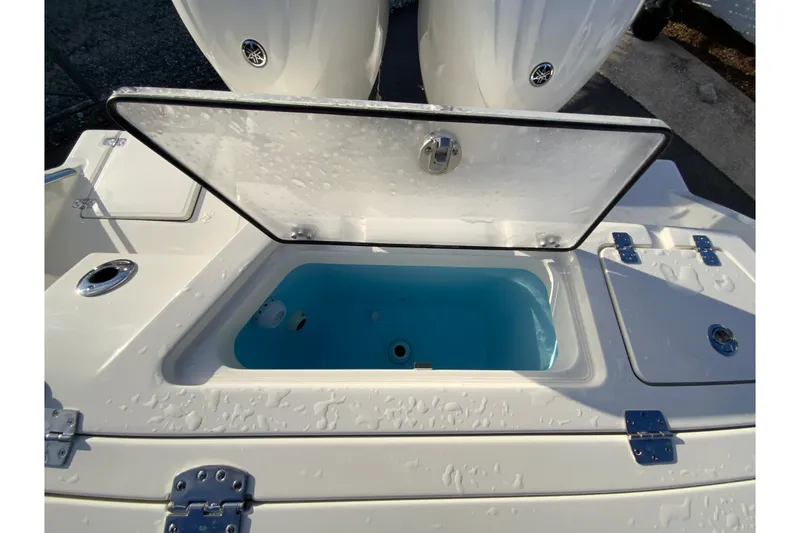 Slide: The Image of 2026 Cobia 245 Center Console boat with open storage compartment, showcasing sleek design and functionality. - 15