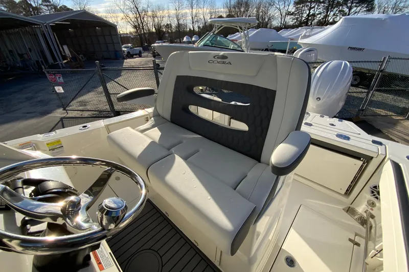 Slide: The Image of 2026 Cobia 245 Center Console boat interior with steering wheel and cushioned seating. - 22