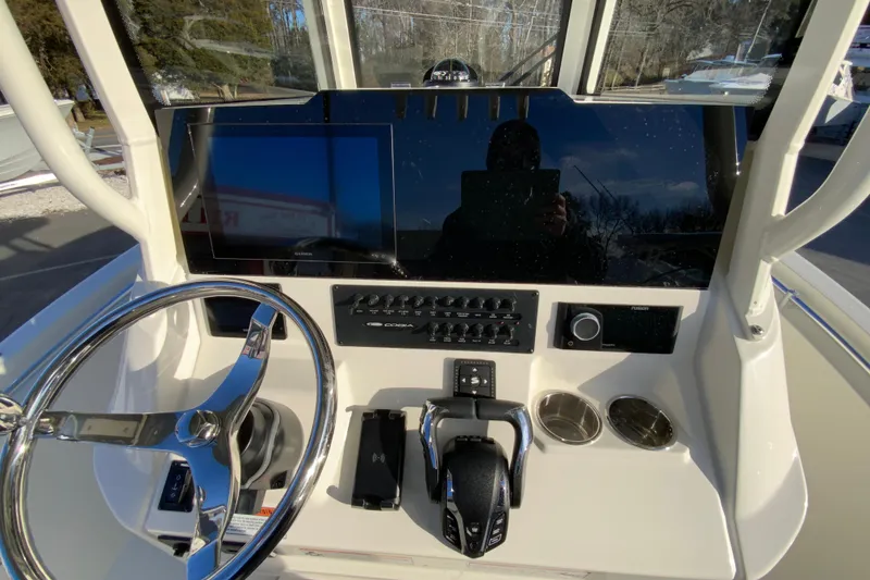 Slide: The Image of 2026 Cobia 245 Center Console boat dashboard with steering wheel and controls. - 23