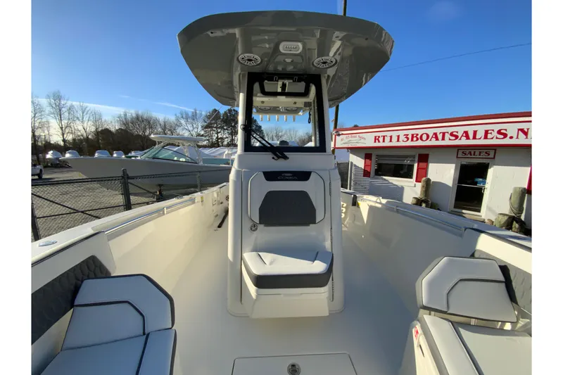 Slide: The Image of 2026 Cobia 245 Center Console boat at dealership, showcasing seating and helm. - 30
