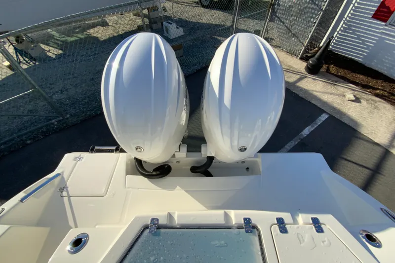 Slide: The Image of 2026 Cobia 245 Center Console with dual outboard engines, docked in a marina. - 37