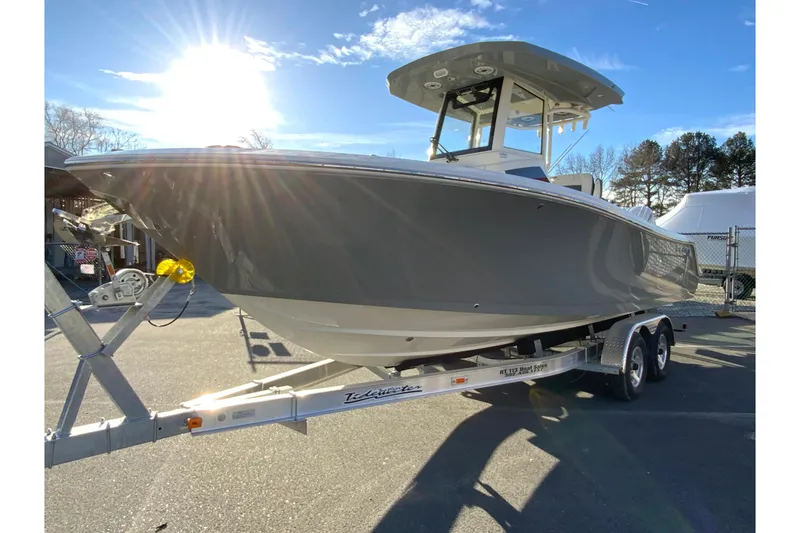 Slide: The Image of 2026 Cobia 245 Center Console boat on trailer under bright sunlight. - 5
