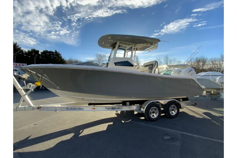 Slide: The Image of 2026 Cobia 245 Center Console boat on trailer under a clear blue sky. - 6