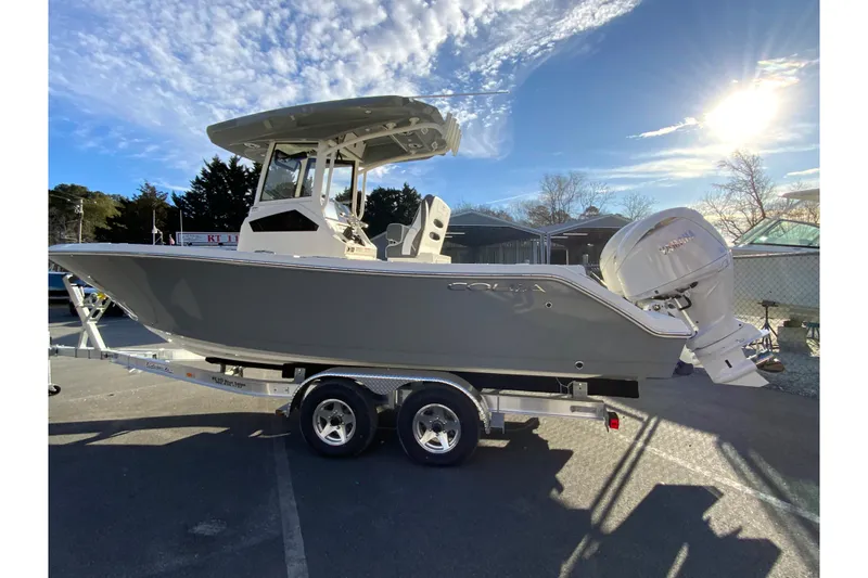 Slide: The Image of 2026 Cobia 245 Center Console boat on trailer under sunny sky. - 7