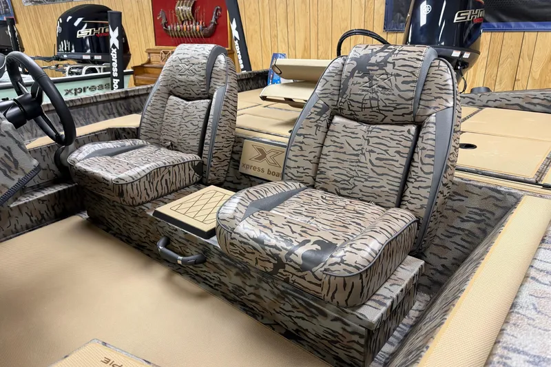 Slide: The Image of 2026 Xpress H18C Crappie boat interior with camo-patterned seats and steering wheel. - 5