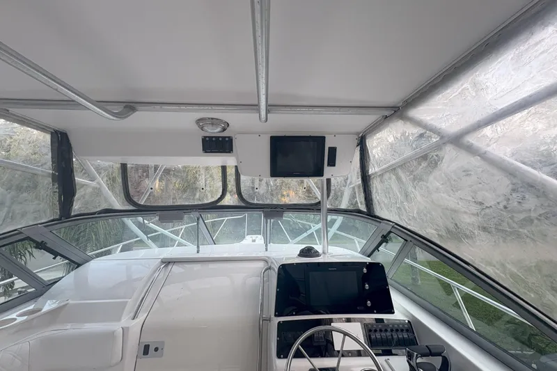 Slide: The Image of 2001 Boston Whaler 285 Conquest interior with white seating and wooden flooring. - 12