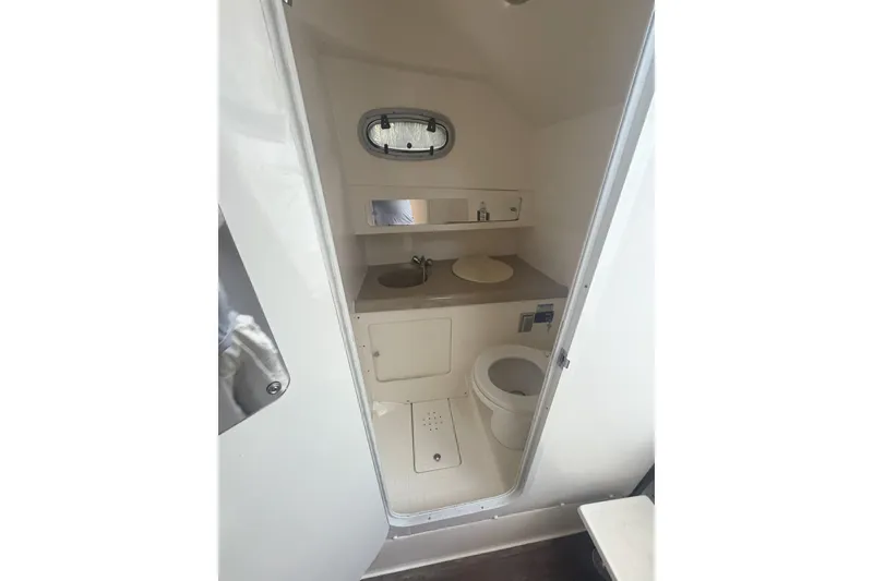 Slide: The Image of 2001 Boston Whaler 285 Conquest boat bathroom with sink, toilet, and porthole window. - 7