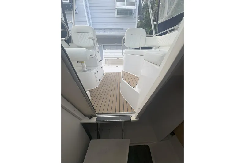Slide: The Image of 2001 Boston Whaler 285 Conquest interior with white seating and wooden flooring. - 8