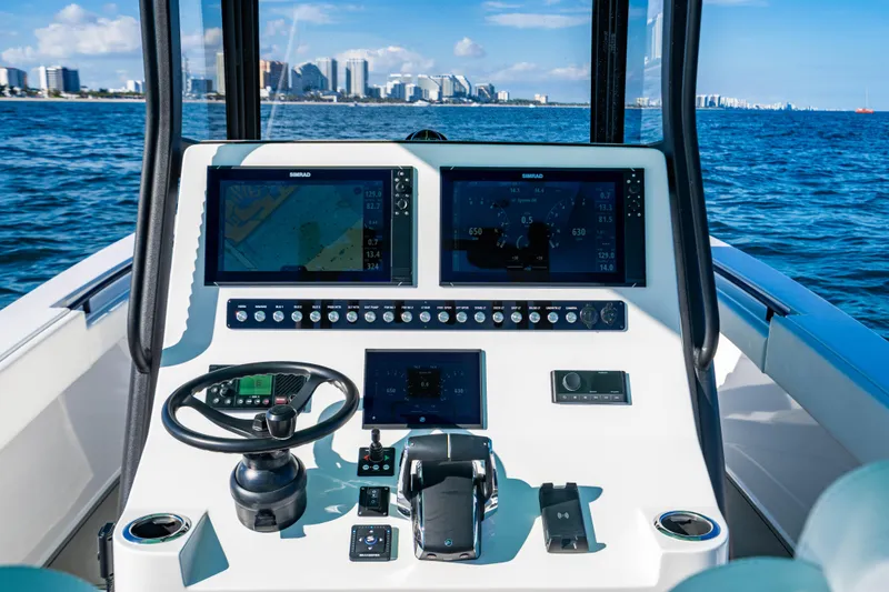 Slide: The Image of 2026 Reef Runner 340 boat dashboard with navigation screens, steering wheel, and ocean view. - 13