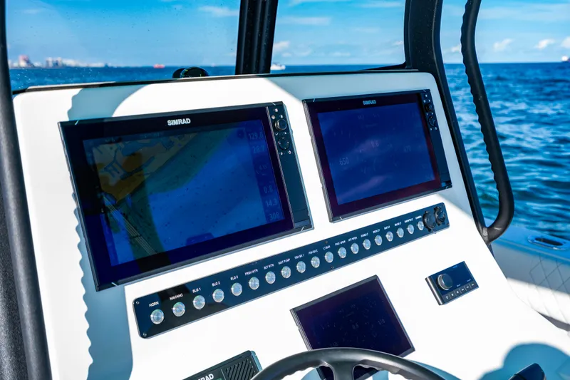 Slide: The Image of Control panel of 2026 Reef Runner 340 boat with navigation screens, ocean view. - 17