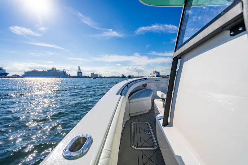 Slide: The Image of 2026 Reef Runner 340 boat cruising on sunny ocean with distant ships and clear sky. - 21