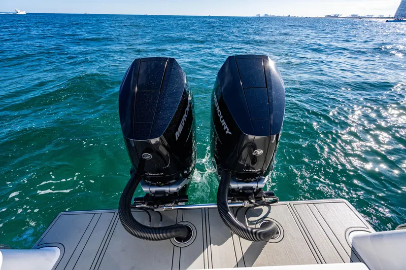 Slide: The Image of Twin Mercury outboard engines on a 2026 Reef Runner 340 boat, cruising on open water. - 5