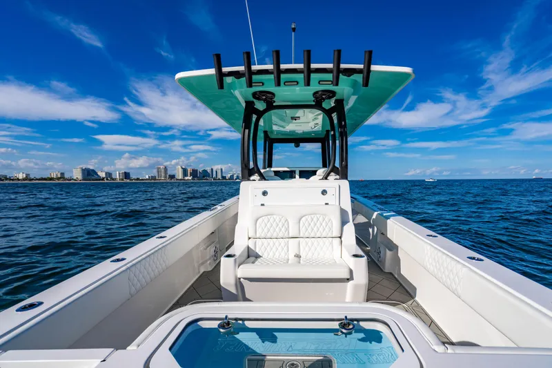 Slide: The Image of 2026 Reef Runner 340 boat on open water with city skyline in background. - 8