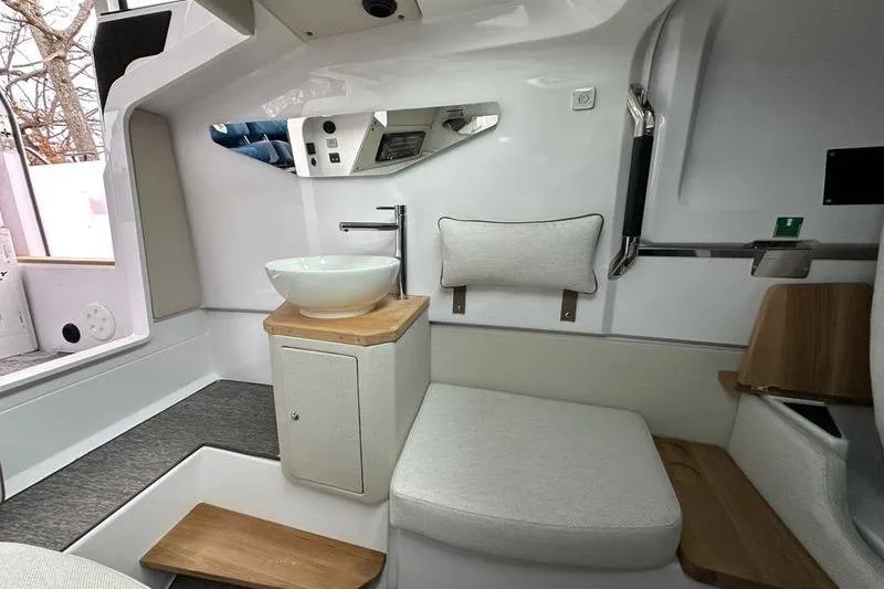 Slide: The Image of 2025 Axopar 37 XC Cross Cabin interior with modern sink and seating area. - 18