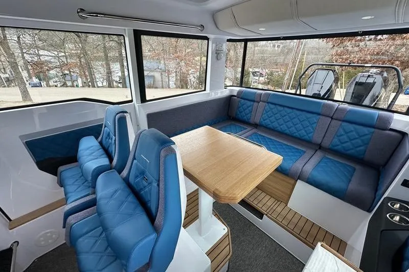Slide: The Image of Luxurious interior of 2025 Axopar 37 XC Cross Cabin with blue seating and wooden table. - 19