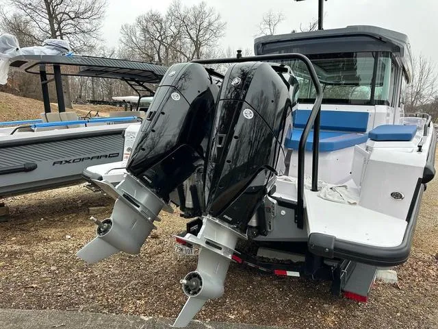 Slide: The Image of 2025 Axopar 37 XC Cross Cabin with blue cushioned deck, docked at marina. - 3