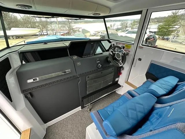 Slide: The Image of 2025 Axopar 37 XC Cross Cabin interior with modern dashboard and blue seating. - 6