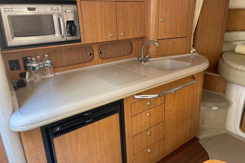 Slide: The Image of 2006 Sea Ray 340 Sundancer galley with sink, microwave, and storage cabinets. - 3