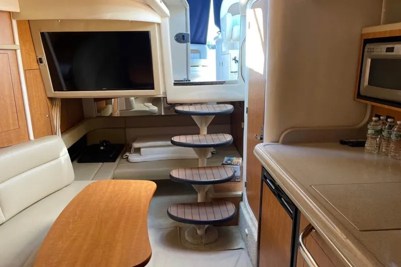 Slide: The Image of Interior of 2006 Sea Ray 340 Sundancer yacht with TV, kitchenette, and seating area. - 4