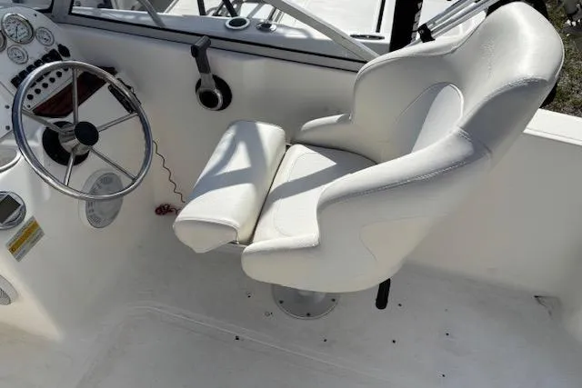 Slide: The Image of 2001 Sea Pro 190 Dual Console boat interior with steering wheel and white captain's chair. - 12