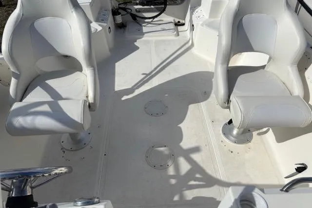 Slide: The Image of 2001 Sea Pro 190 Dual Console boat interior with two white seats and steering wheel. - 13