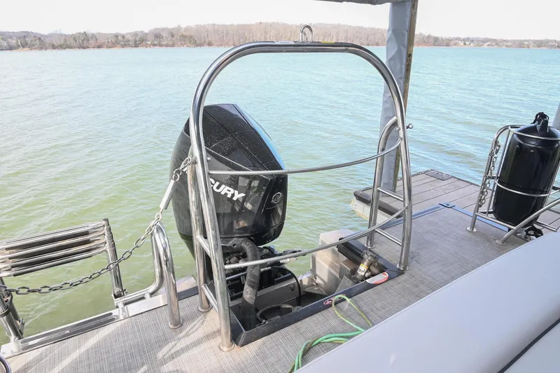 Slide: The Image of 2021 Harris Sunliner 230 boat with Mercury outboard motor on a lake. - 11