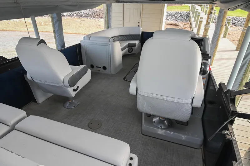 Slide: The Image of Interior of 2021 Harris Sunliner 230 pontoon boat with plush seating and helm station. - 15