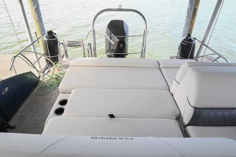 Slide: The Image of 2021 Harris Sunliner 230 boat interior with comfortable seating and water view. - 16