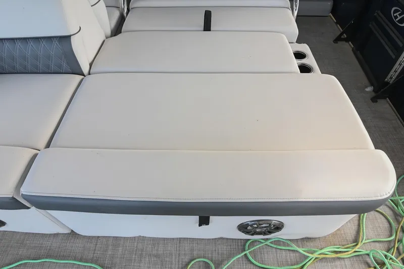 Slide: The Image of 2021 Harris Sunliner 230 boat interior seating with cup holders and speaker. - 19