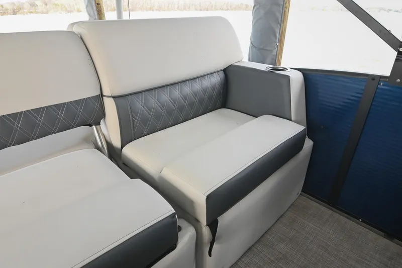 Slide: The Image of 2021 Harris Sunliner 230 boat interior with cushioned seating and cup holder. - 22
