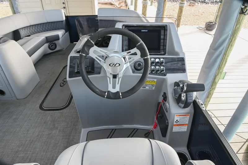 Slide: The Image of 2021 Harris Sunliner 230 boat interior with steering wheel and control panel. - 25