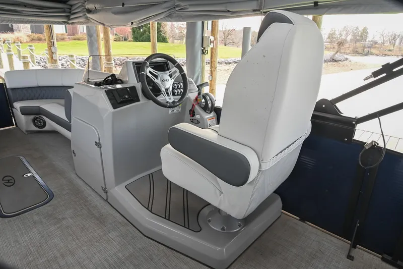 Slide: The Image of Interior of 2021 Harris Sunliner 230 boat with steering console and seating. - 26