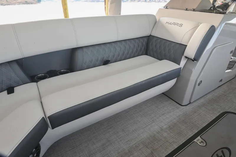 Slide: The Image of 2021 Harris Sunliner 230 boat interior with gray cushioned seating and cup holders. - 42