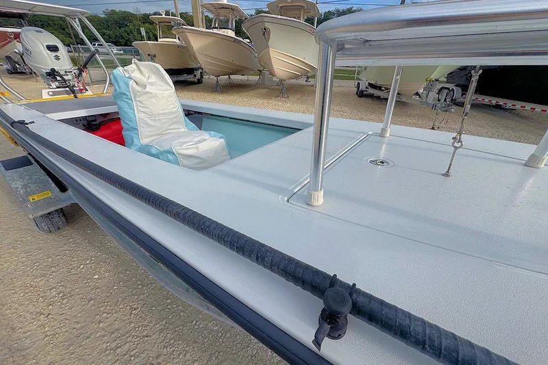 Slide: The Image of 2021 East Cape Glide boat with cushioned seating, displayed outdoors on a trailer. - 11