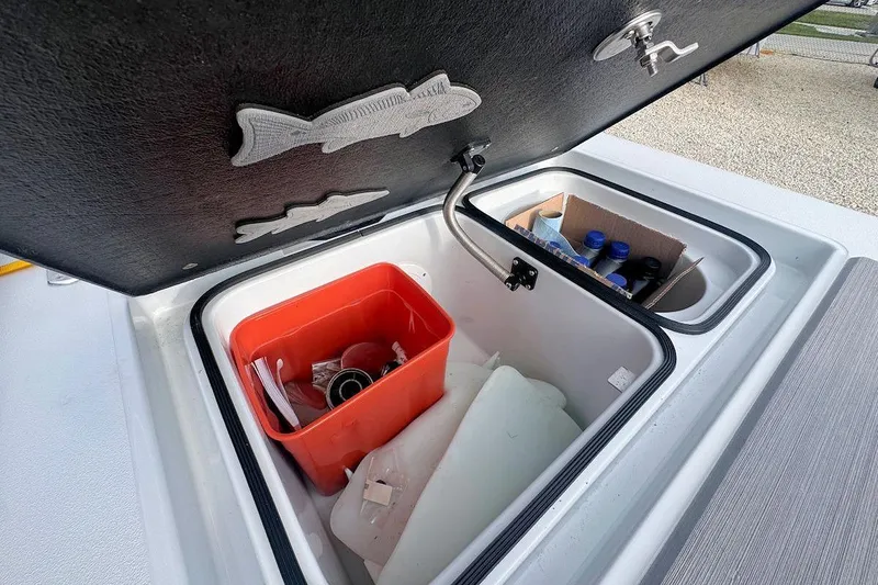 Slide: The Image of Open storage compartment in 2021 East Cape Glide boat with red bin and supplies. - 14