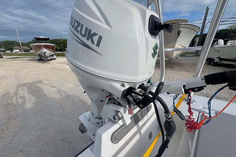 Slide: The Image of 2021 East Cape Glide boat with Suzuki outboard motor in a marina setting. - 5