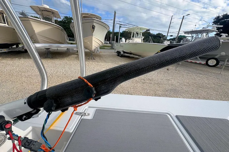 Slide: The Image of 2021 East Cape Glide boat with carbon fiber push pole, docked near other boats. - 7